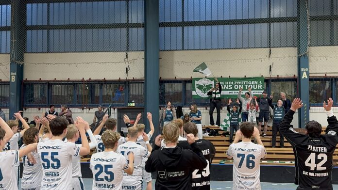 Die Mannschaft der DJK feiert die Tabellenführung mit den mitgereisten Fans (Foto: Kristof Marzinkowski)